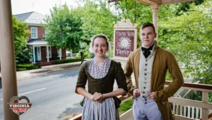 two people in colonial-era dress in front of Rising Sun Tavern