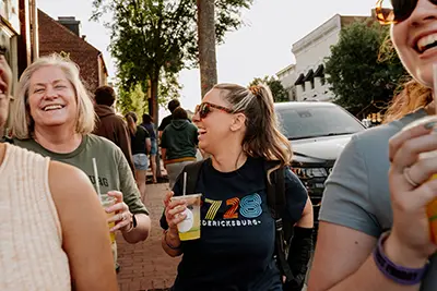 women laughing while walking down the sidewalk on First Friday