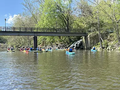 kayakers on a river near a bridge